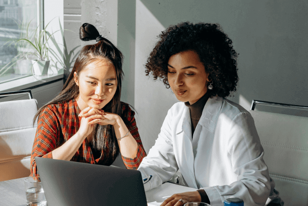 Woman looking at a laptop together, pleased with what they see