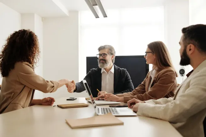 man and woman shaking hands across the table